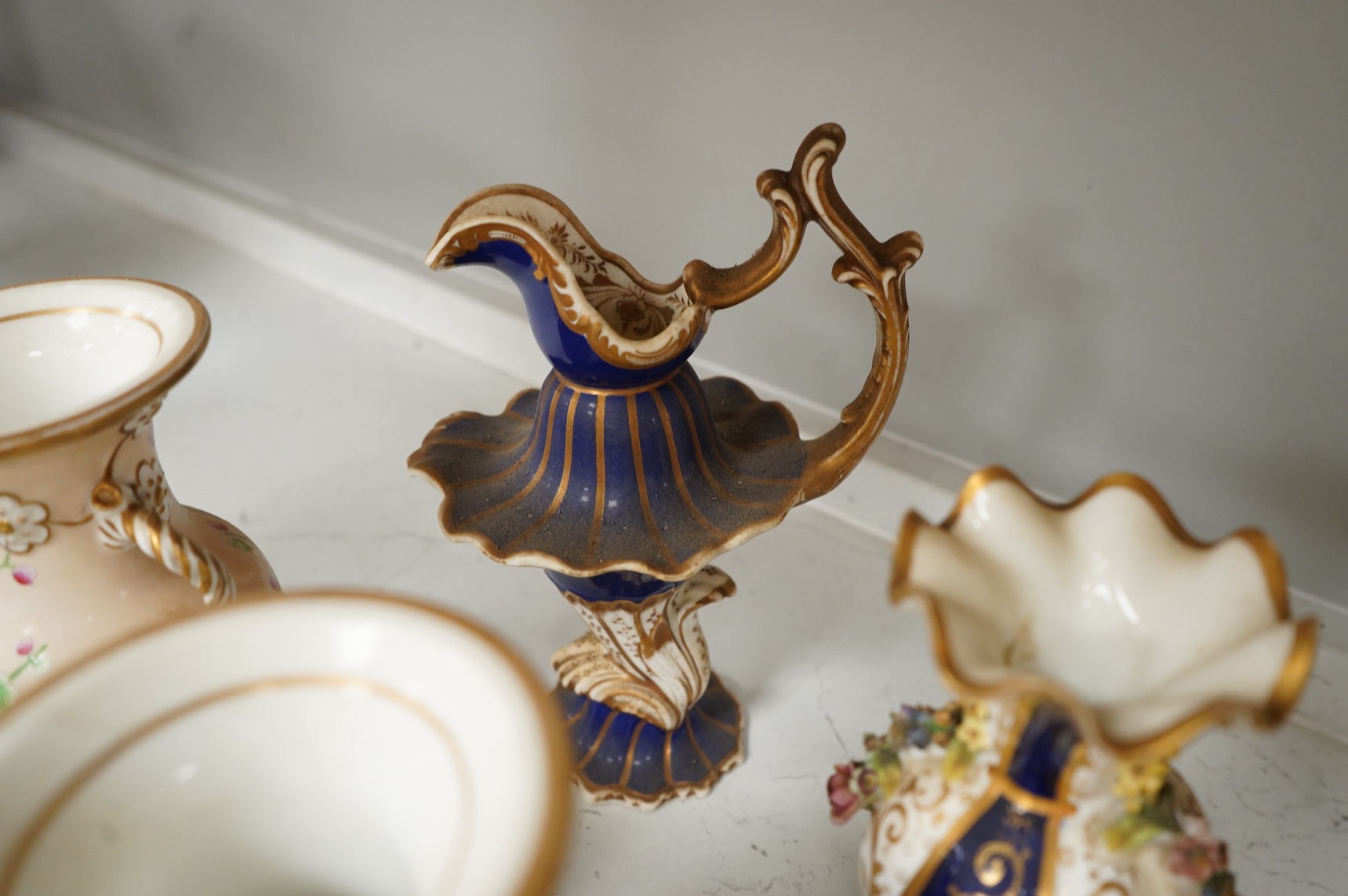 Large group of 19th/20th century English ceramics, to include a Rockingham basket, other English porcelain flower encrusted vessels, a Copeland and Garrett ewer, a Minton Sevres style beaker, a Wedgwood agate ware jug, R